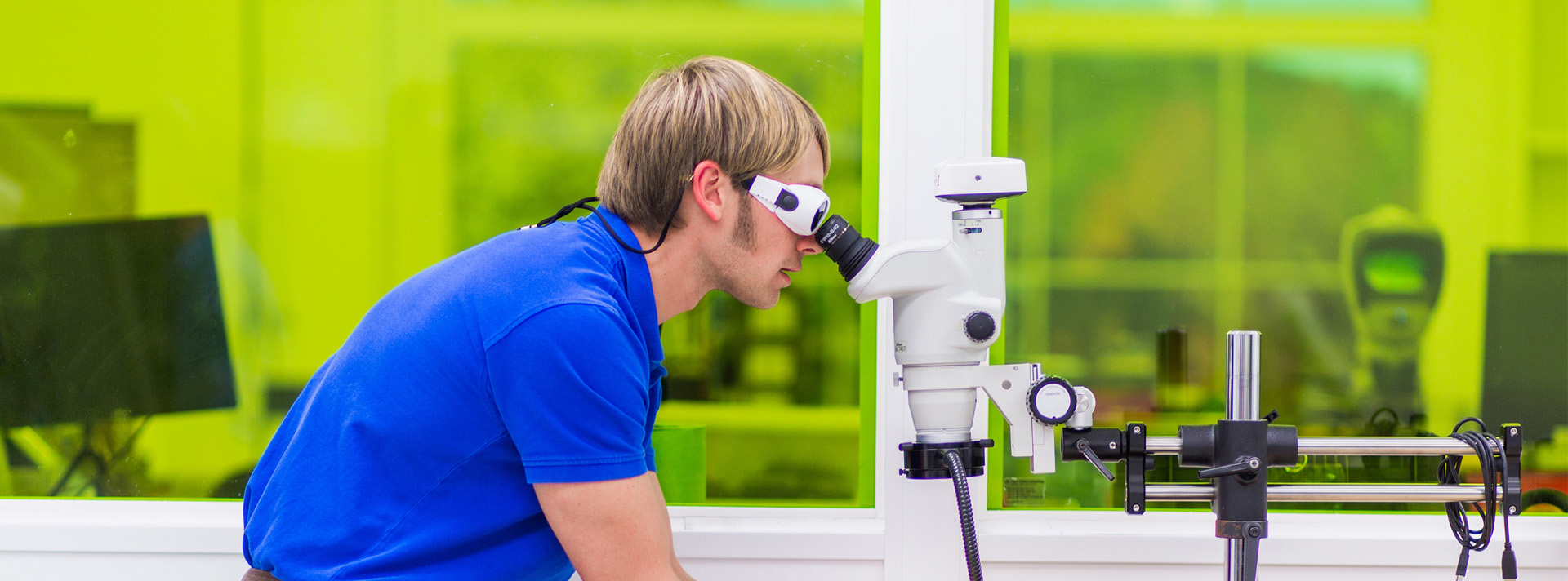 Cadence employee looking through microscope